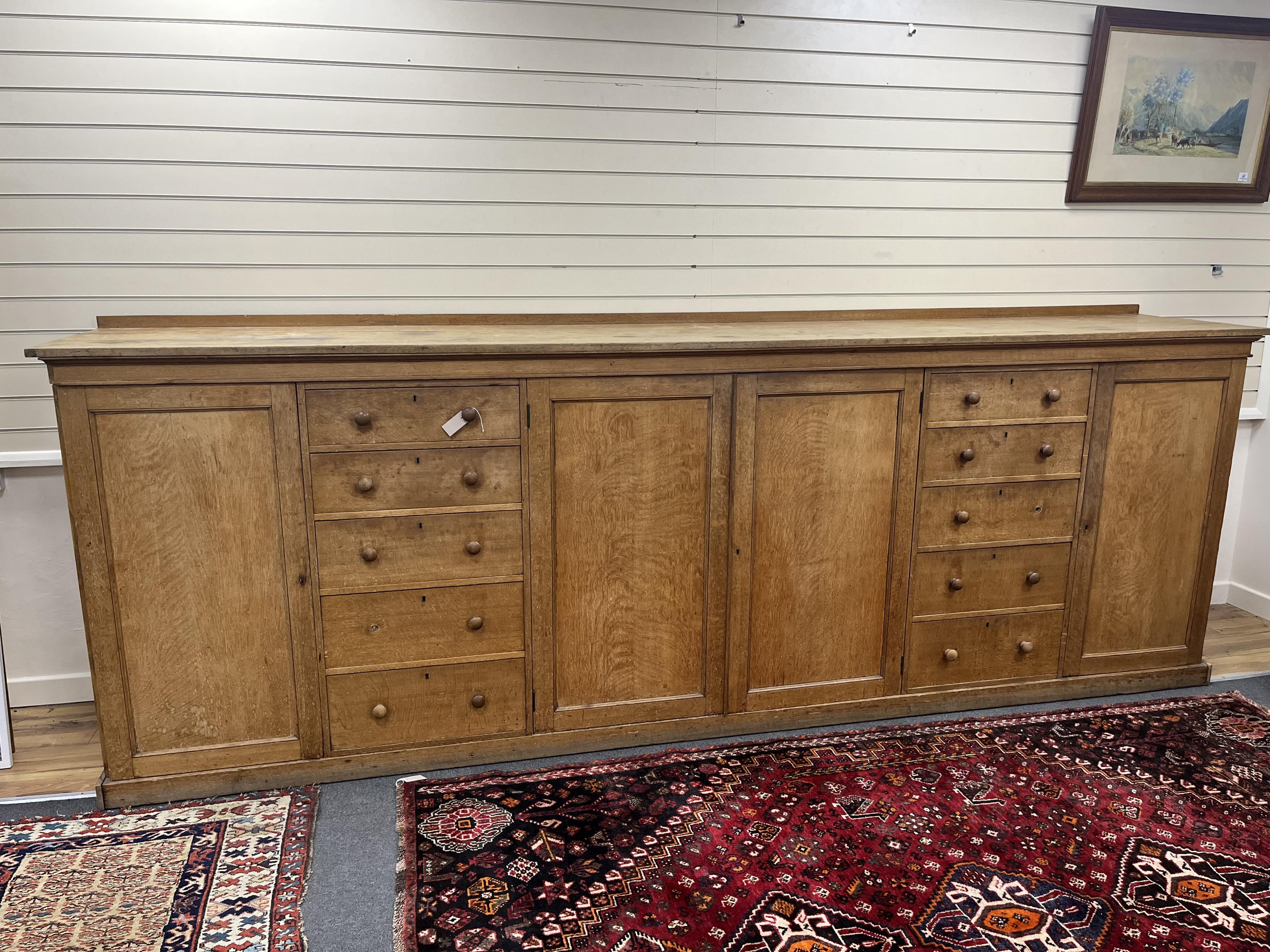 A late Victorian oak estate press cupboard, width 366cm, depth 64cm, height 130cm. Condition - fair